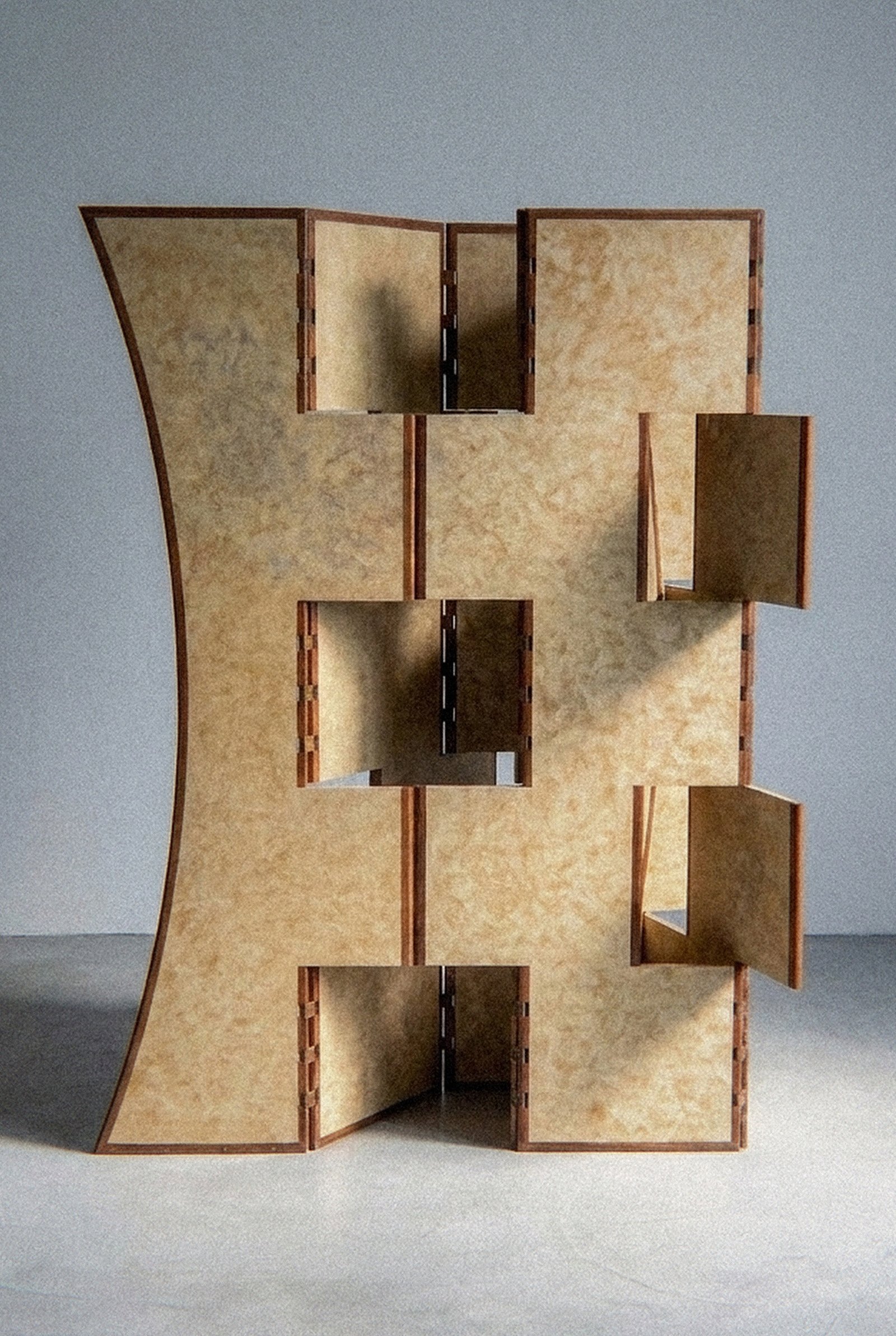 Vista próxima da escultura móvel Macho com painéis articulados de ipê e abas retangulares abertas.