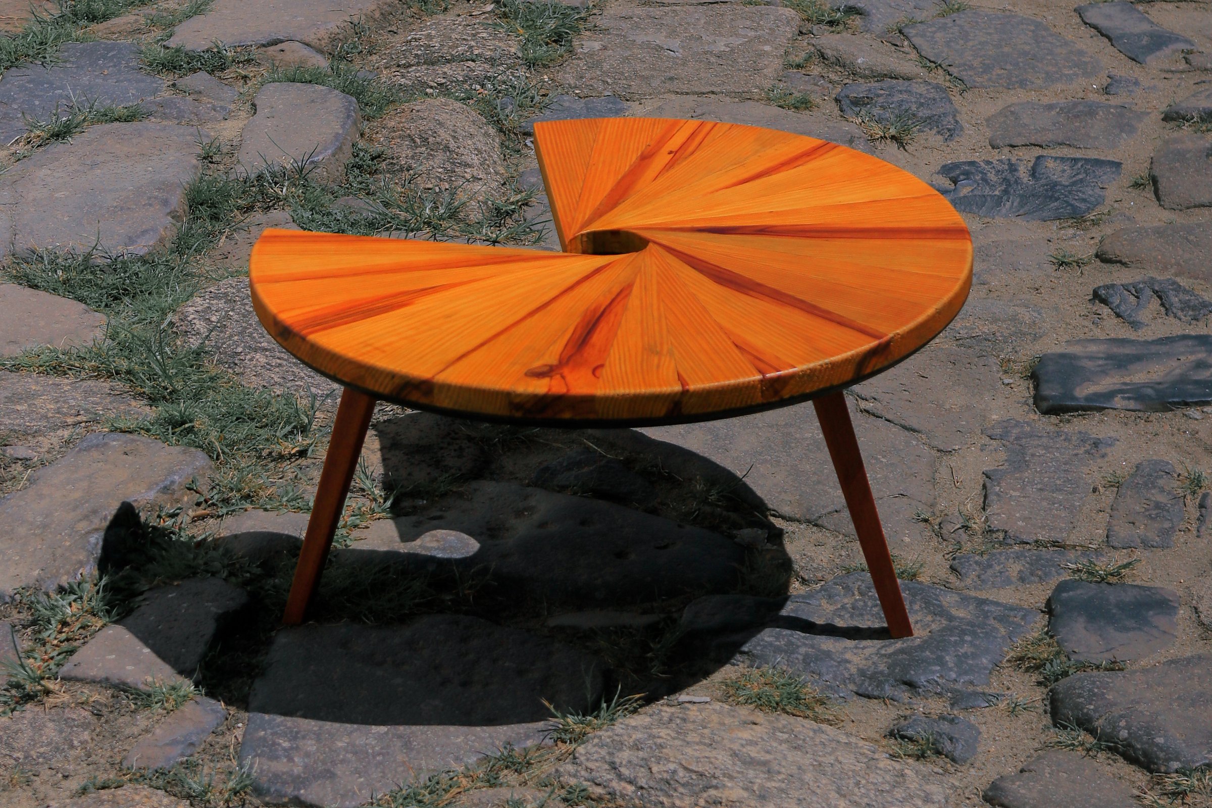 Mesa Caracol sob luz solar direta sobre um piso de pedras irregulares.